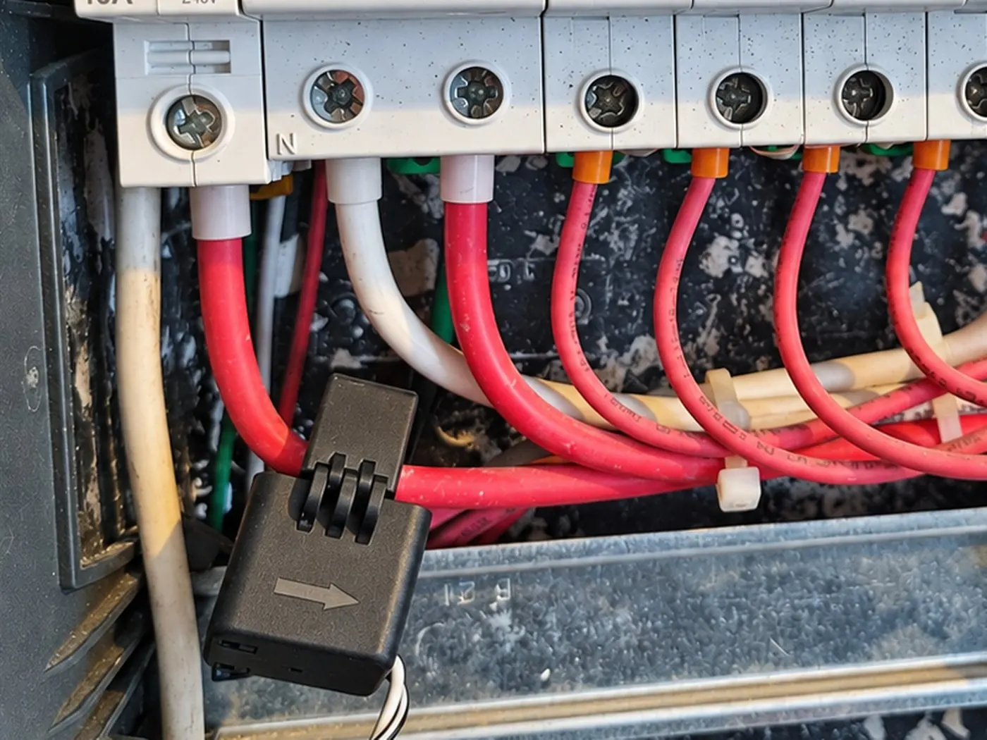 Transformador de corriente abrazando un conductor en tablero